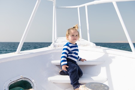 Kid concept. Little kid travel on ship. Kid enjoy sea travelling. Kid on board. Summer vacation and wanderlust.の写真素材