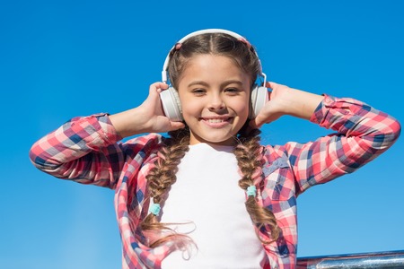 True hapiness. Small music fan. Happy small girl. Small girl listen to music outdoor. Happy child wear headphones. Bring music to life.の写真素材