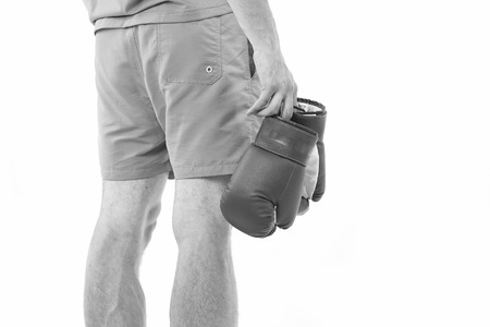 Man in shorts carries boxing gloves rear view isolated white background.