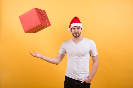 delivery christmas gifts. happy santa man on yellow background. The morning before Xmas. man in santa hat hold christmas present. online christmas shopping. Happy new year. Winter holidays sales.の写真素材