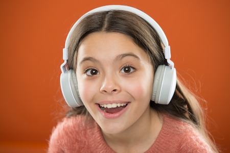 Girl child listen music modern headphones close up. Get music subscription. Access to millions of songs. Enjoy music concept. Best music apps that deserve a listen. Listen for free.の写真素材