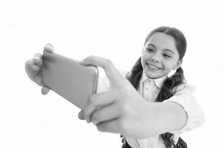 Let me take selfie. Girl cute long curly hair holds smartphone taking selfie whiteの写真素材