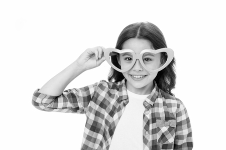 Lovely glance. Kid girl heart shaped eyeglasses cheerful. Girl curly hairstyle adorable smiling face. Child charming smile isolated white background. Kid happy lovely enjoy childhood.の写真素材