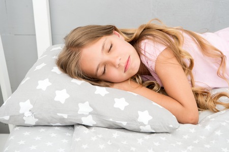 Healthy sleep tips. Girl sleep on little pillowの写真素材