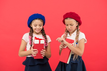 Kids little girls in school uniform and berets hold gifts boxes.の写真素材
