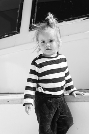Kids fashion on vacation. Boy adorable sailor striped shirt yacht travel around world. Baby boy enjoy vacation cruise ship. Dress your kid comfortable let him choose favorite clothing. Voyage fashion.の写真素材