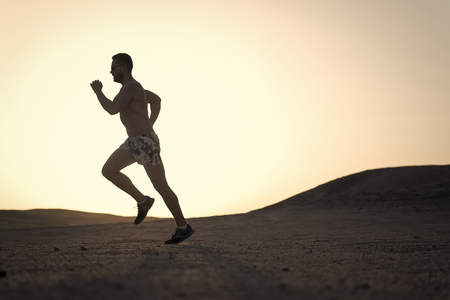 running man on mountain nature landscape on sky background in summer or spring, business and success, energy fitness, gym and health, sport and recreationの写真素材