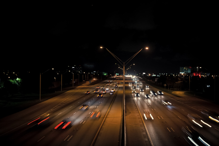 Highway road with car trails at night on dark sky background. Traffic, speed, motion concept....