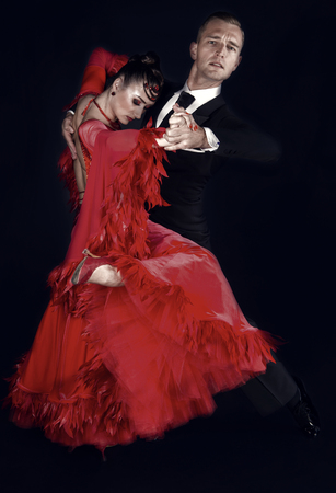 dance ballroom couple in red dress dance pose isolated on black background. sensual professional dancers dancing walz, tango, slowfox and quickstep.の写真素材