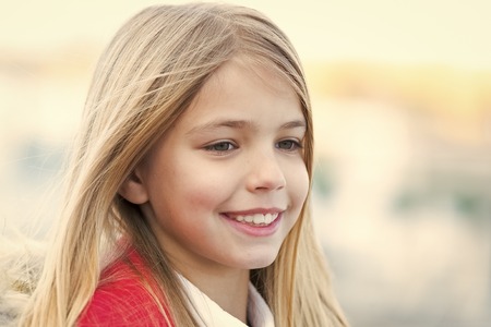 Beauty, look, hairstyle. Girl with blond long hair on autumn day outdoor. Happy childhood concept....
