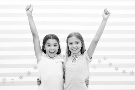 Live happy moments together. Kids schoolgirls preteens happy together. Friendship from childhood. Girls smiling happy faces hug each other stand striped background. Girls children best friends hug.の写真素材