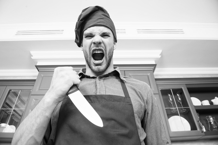Sharp knife professional tool. Chef choose professional tools. Kitchen utensils and tools. Chef hold knife tool ready to cook. Man chef wear apron cooking in kitchen. Man use sharp ceramic knife.の写真素材
