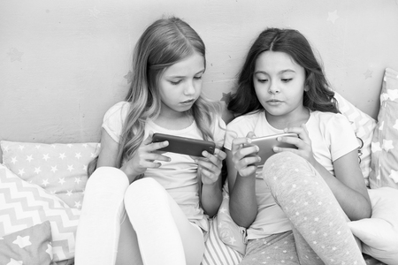 Smartphone application concept. Girlish leisure pajama party. Girls smartphone little bloggers. Online entertainment. Explore social network. Smartphone for entertainment. Kids taking selfie.の写真素材