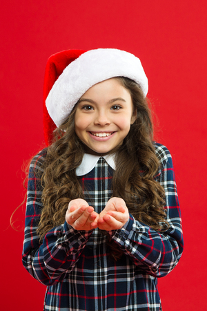 Be happy. Little girl child in santa red hat. Christmas shopping. Happy winter holidays. Small girl. Present for Xmas. Childhood. New year party. Santa claus kid. Its yours.の写真素材