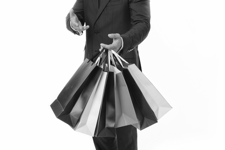 Recommend to buy. Hands of shopper carries shopping bags white background. Successful businessman choose only luxurious brands and shopping in high fashioned boutiques. Corporate discount sale.の写真素材