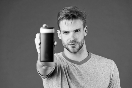 Man bearded stylish holds plastic bottle. Guy handsome care about appearance use cosmetic or hygienic product. Man show his favorite shampoo or conditioner for hair. Shampoo bottle best choice.の写真素材