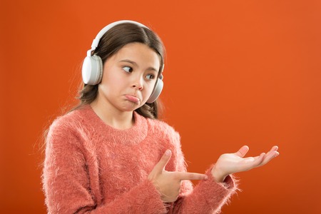 Earphones wireless modern technology. Get music account subscription. Enjoy music concept. Check out music service copy space. Girl child listen music wireless headphones pointing with index finger.の写真素材