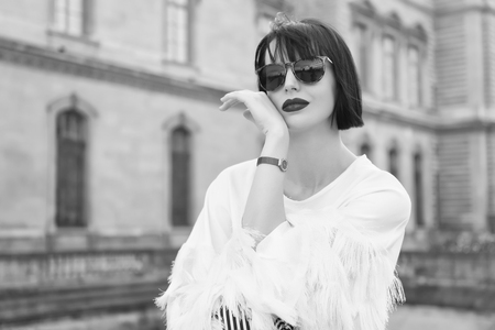 Bright makeup universal accessory. Woman fashionable model posing outdoor. Girl brunette bob hairstyle looks stylish. Girl fashionable lady with bob hairstyle outdoor urban architecture background.の写真素材
