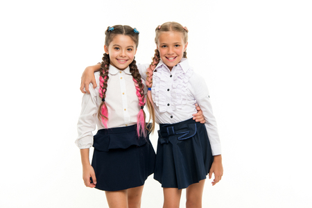 Be bright. School friendship. Sisterhood relationship and soulmates. On same wave. Schoolgirls wear formal school uniform. Sisters little girls with braids ready for school. School fashion concept.の写真素材