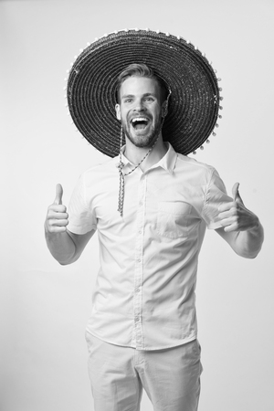 Man cheerful face festive mood posing in sombrero hat yellow background. Guy with bristle looks festive in sombrero. Fest and holiday concept. Man celebrate mexican national traditional holiday.の写真素材