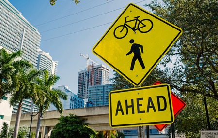 Traffic signs on city road in miami, usa. Bicycle and pedestrian crossing ahead warning. Transportation traffic and travel. Caution and warn concept.の写真素材