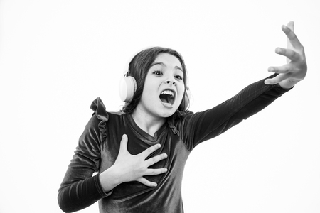 Enjoying her favorite music. Little music lover. Small girl listen and sing to music. Little child wear headphones. Emotional small singer. Music is my life.の写真素材