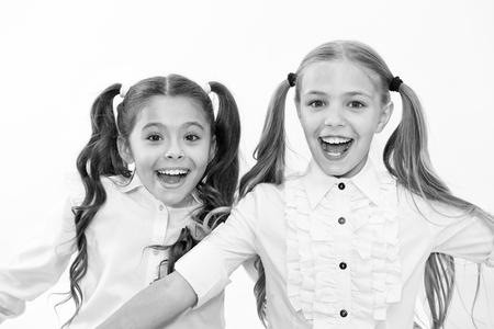 Schoolgirls with cute ponytails hairstyle and brilliant smiles. Best friends excellent pupils. Perfect schoolgirls tidy appearance glad to meet you. Meet new friends in school. Let us get acquainted.の写真素材