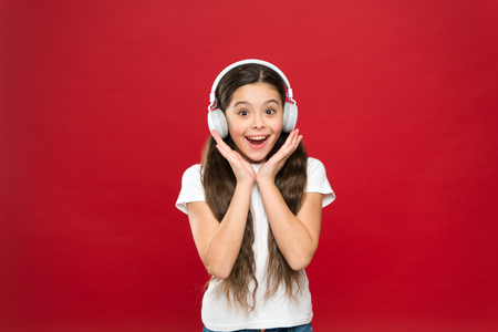 Girl listen music headphones on red background. Play list concept. Music taste. Music plays an important part lives teenagers. Powerful effect music teenagers their emotions, perception of world.の写真素材