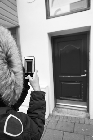 Daily photo shooting. Mobile app camera. Tourist photographer concept. App for shooting mobile phone photos high quality. Someone taking mobile photo house entrance with red door.の写真素材