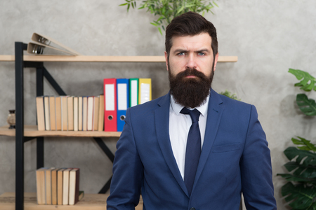 Business banker. Modern businessman. Confident brutal man. Male in business office. Bearded man banker. Mature hipster with beard. Businessman in suit. Man banker. Serious banker in bank office.の写真素材