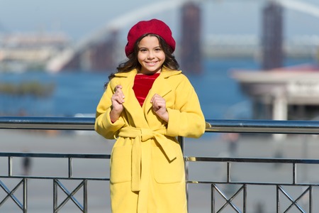French style trend. Carefree relaxed walk. Health benefits of walking. Girl adorable kid walk defocused background. Fashionable girl enjoy walk on sunny spring day. Kid bright hat beret and warm coat.の写真素材
