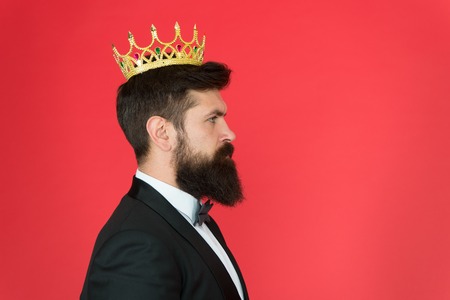 King attribute. Narcissistic king. Self confidence concept. Handsome hipster formal suit. Elite society. Feeling superior. Man bearded guy in tuxedo golden crown symbol of monarchy. King ceremony.の写真素材