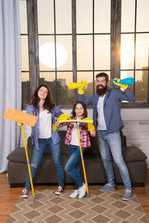 Householding team. Preparing For Life. Family clean house. Happy family hold cleaning products. Mother, father and daughter clean house. Householding. Householding people. Householding chemicals.の写真素材