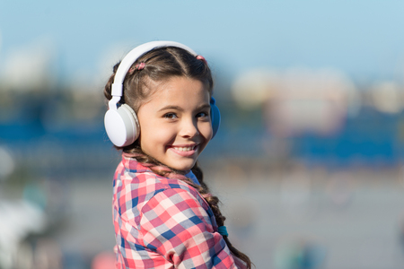 Music gives her great pleasure. Cute child with wireless headset. Small child wearing stereo headphones. Little child listening to music. Adorable child using technology for leisure or education.の写真素材