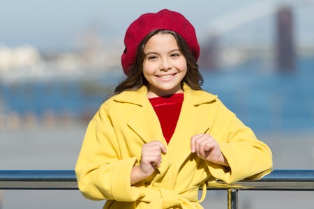 Girl adorable kid walk defocused background. Kid bright hat beret and warm coat. French style trend....