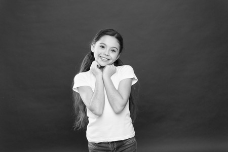 Smiling sweetly. Adorable little girl with no makeup. Beauty look of skincare model. Beauty cosmetics for kids. Pretty girl enjoys young healthy skin. The perfect face care and skincareの写真素材