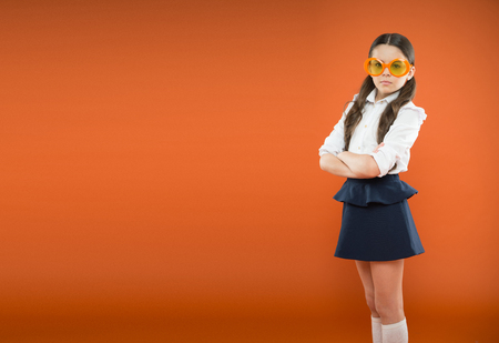 Prepare kid first school day. Schoolgirl cute ponytails. Excellent pupil concept. Girl wear school uniform orange background. School education. Lets begin school year. Perfect schoolgirl tidy hairの写真素材