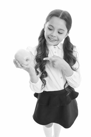 Detox and diet. Girl pupil hold apple fruit on white background. Healthy nutrition diet, Kid happy hold apple. School snack concept. Apple vitamin snack. Schoolgirl wear formal uniform hold apple.の写真素材