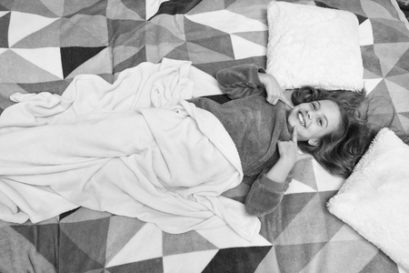 Little happy girl in bedroom. Good morning. International childrens day. Small girl child ready to sleep. Time to relax. Childhood happiness. Pajama party. Good night. feeling comfortable in bedroom.の写真素材