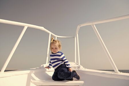 Around world. Child cute sailor on yacht sunny day. Adventure of boy sailor travelling sea. Boy adorable sailor striped shirt white yacht travel around world. Baby boy enjoy vacation on cruise ship.の写真素材