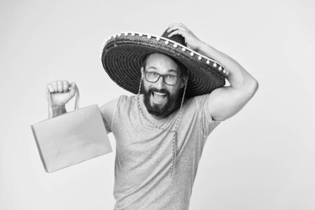 Buy souvenir from travel. Man wear sombrero hat shopping yellow background. Guy with beard happy in sombrero.の写真素材