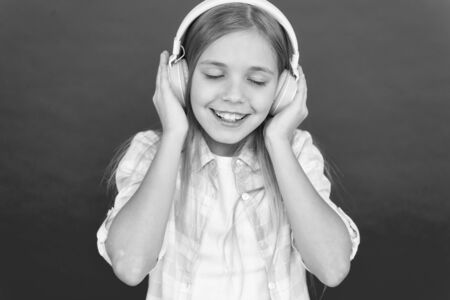 Girl child listen music modern headphones. Get music account subscription. Enjoy music concept. Music always with me. Little girl listen song headphones. Online radio station channel. Leisure concept.の写真素材