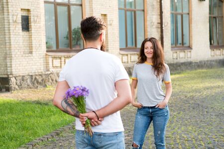 Romantic date idea. Guy prepared surprise bouquet for girlfriend. True feelings. Bearded hipster fall in love. Couple meeting for date. Man giving flowers. Golden rules perfect date. Simple happiness.の写真素材