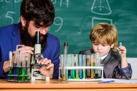 Pupil kid in the chemistry class confidence charisma. Back to school. Science chemistry concept. bearded man teacher with little boy. father and son at school. instruction is life itselfの写真素材