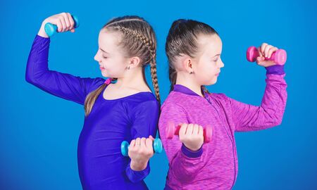 weight lifting for bodycare muscules. Childhood bodycare. Fitness diet for energy health. Happy children with barbell. Sport success. workout of small girls hold dumbbell. bodycare conceptの写真素材