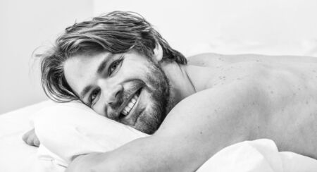 Morning routine tips to feel good all day. Man handsome guy lay in bed in morning. Tips on how to wake up feeling fresh and energetic. How to get up in morning feeling fresh. Enjoy every morningの写真素材