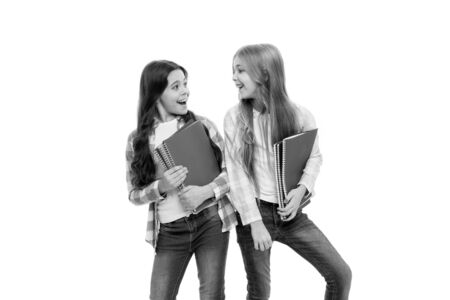 School stationery. Pupils carrying big textbooks to school classes. Taking extra classes. Girls with school textbooks white background. Happy to be students. School supplies concept. We love studyの写真素材