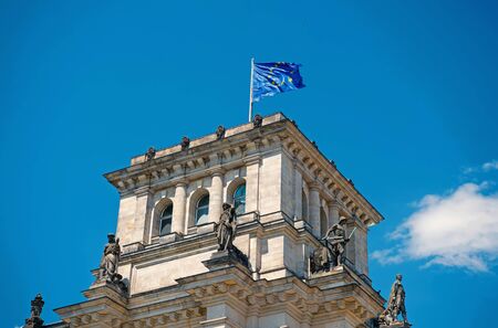 european union flags waving in the wind at famous Reichstag building, seat of the German Parliament Deutscher Bundestag , on a sunny day with blue sky and clouds, central Berlin Mitte district, Germanyの写真素材