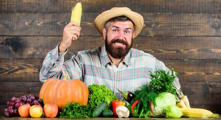 Become organic farmer. Farmer with organic homegrown vegetables. Grow organic crops. Community gardens and farms. Homegrown organic food. Healthy lifestyle. Man with beard wooden backgroundの写真素材