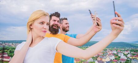 3 happy people on phone. Group of young people standing in a rowの写真素材